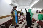 حنا حمادی 18 ساله، 7 سال است که در تعزیه خوانی ایفای نقش می کند. ابتدا با معرفی دوستان بازیگرش به تعزیه خوانی روی آورد؛ حنا همچنین بازیگر تئاتر است و در این تعزیه نقش حضرت زینب (س) را اجرا می کند. 
همچنین فرزاد رضایی پور، 27 سال دارد. 7 سال است که تعزیه خوانی را اجرا می کند او علاوه بر این، بازیگر تئاتر کودکان هم هست. در این تعزیه نقش عمر بن سعد را ایفا می‌کند.
در این تصویر آقای رضایی‌پور و خانم حمادی هر دو در حال تمرین پیش از اجرا هستند.