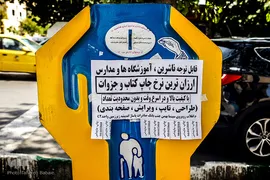 چسباندن پوسترهای تبلیغاتی بر روی صندوق صدقه