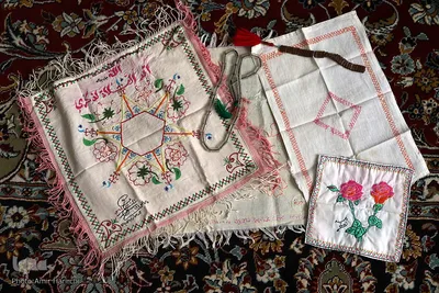 جانمازهایی که محمد جواد سالاریان در دوران اسارت بر روی تکه پارچه های ملحفه و با نخ حوله گلدوزی کرده است.
