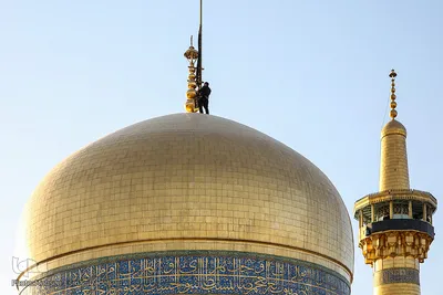 اهتزاز پرچم عزای حسینی بر فراز گنبد حرم رضوی
