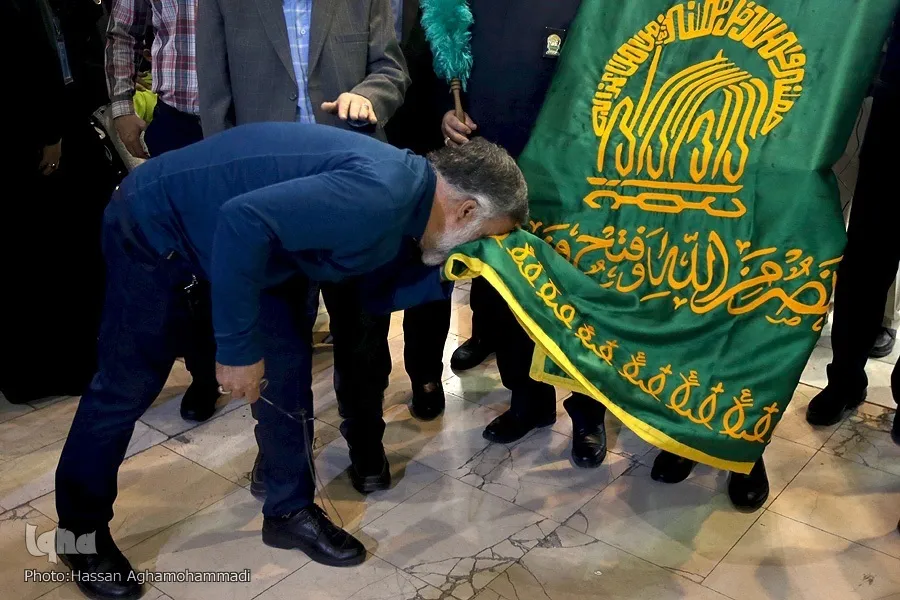پرچم‌گردانی خادمان حرم امام رضا(ع) در نمایشگاه قرآن + عکس