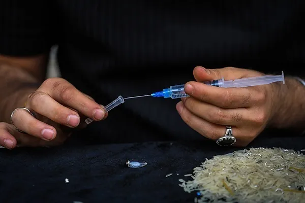 Иракец пишет суры из Корана на зернышках риса