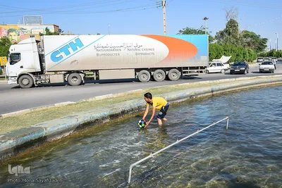 بچه ها در گرمای خرمشهر در میادین شهر تفریح می کنند.