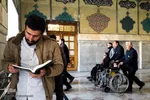 خادمان حرم کودکان مبتلا به سرطان را با ویلچر به سمت حرم امام رضا همراهی می کنند
