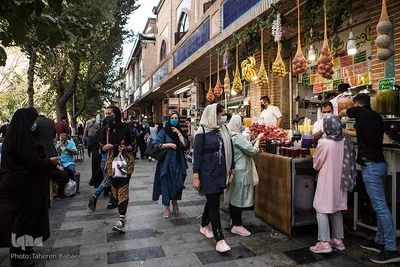 بازار تهران و افرادی که مشغول خرید آبمیوه هستند. طبق اعلام وزارت بهداشت ماندگاری و انتشار ویروس در سطوح زیاد است و آبمیوه‌هایی که آماده می‌شوند برای مشتری بهتر است همان موقع خرید در لیوان ریخته شوند تا ناقل ویروس نباشند. 