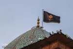 اهتزاز پرچم عزا بر فراز گنبد فيروزه‌اي آستان شاهچراغ(ع)
