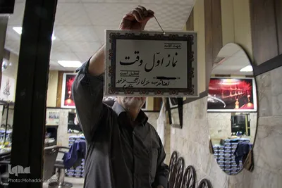 با شنیدن صدای اذان،  جهت اقامه نماز اول وقت آرایشگاه دهقان را تعطیل می‌کند.