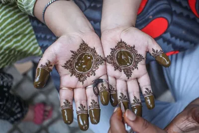 A Kashmiri girl has her hands decorated with henna ahead of Eid Al Adha, in Srinagar, the summer capital of Indian-administered Jammu and Kashmir region. EPA

