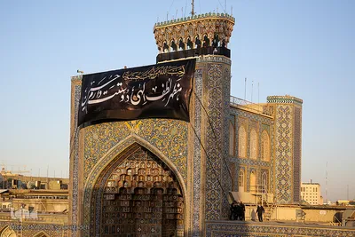 اهتزاز پرچم عزای حسینی بر فراز گنبد حرم رضوی

