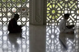 دو نوجوان در حال حفظ کردن آیات قرآن در روز اول رمضان در مسجد " Banda Aceh" اندونزی
