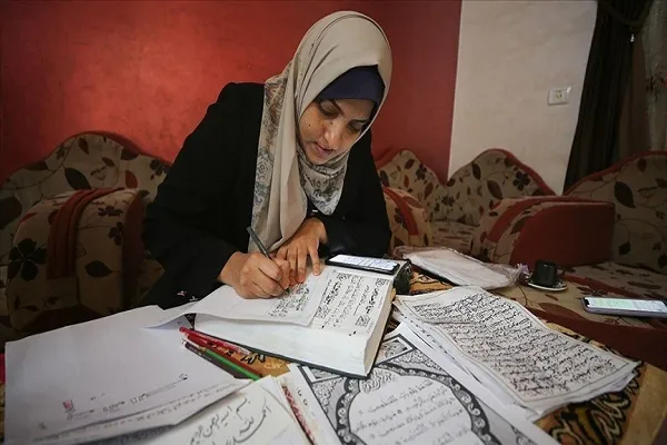 عمل نادر.. أول فلسطينية في غزة تنسخ القرآن بالرسم الكوفي